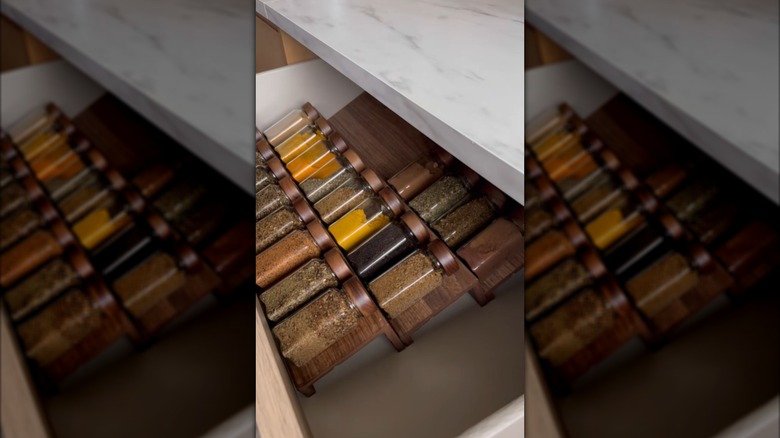 Person using IKEA MOSSLANDA picture ledges to store spices in a drawer