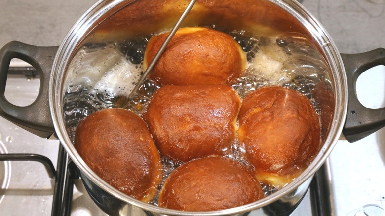 Donuts deep-frying in a stovetop pot.