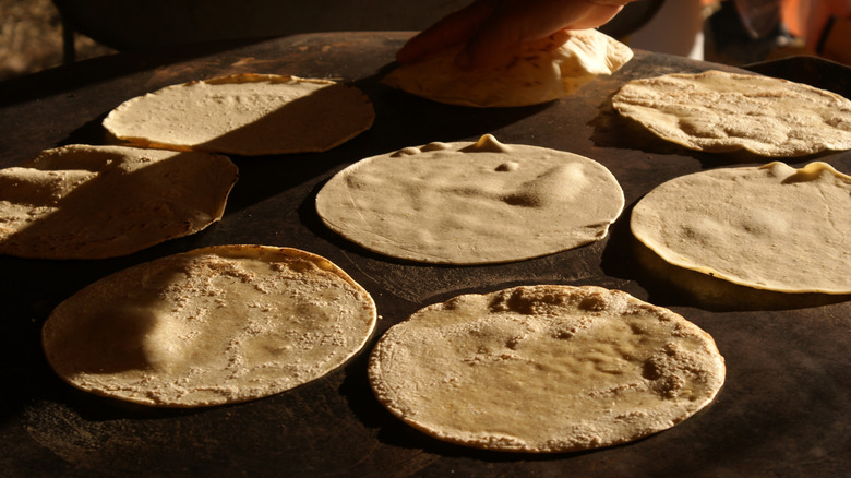 tortillas cooking on a stove
