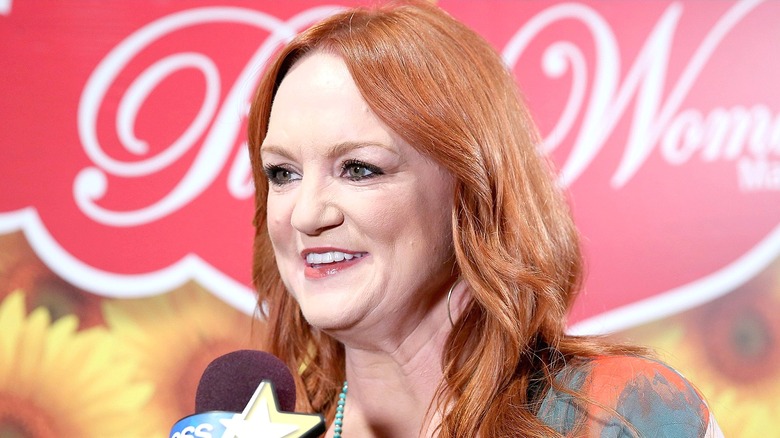 Ree Drummond smiling, while leaning toward a microphone