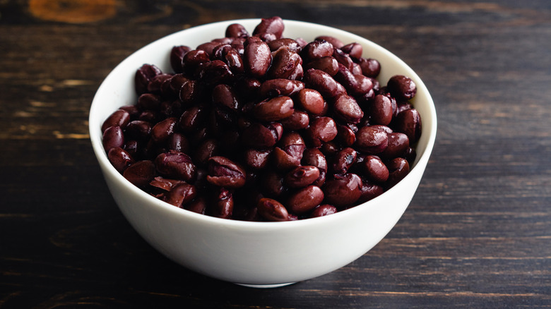 Unseasoned cooked black beans in a small white ceramic bowl