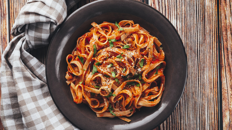 plate of taglietelle pasta with red sauce and parsley
