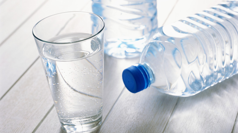 glass of water with bottled water nearby