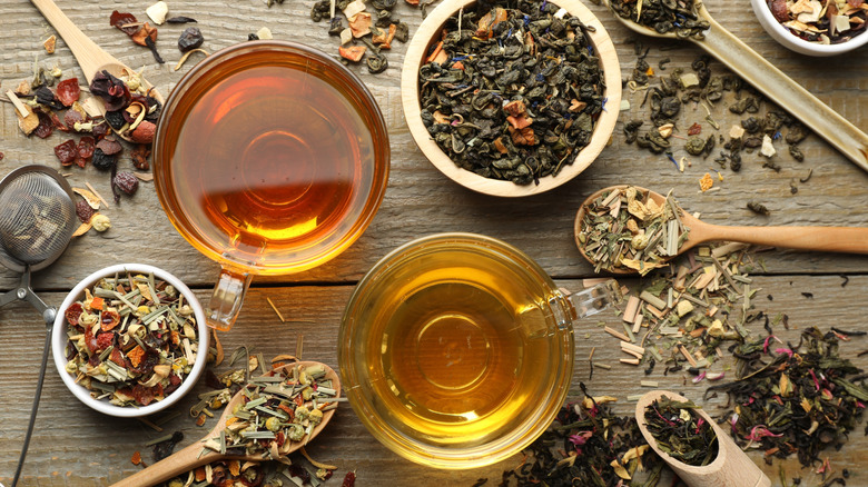 A flatlay of two teas with loose leaves scattered around