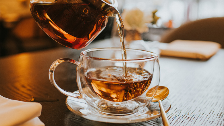 Tea being poured into a clear glass