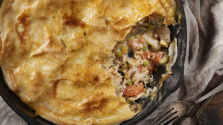 Pot pie in cast iron skillet with piece eaten