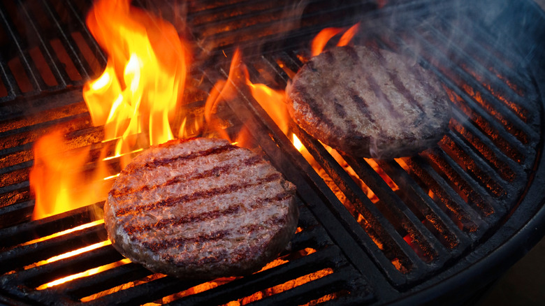 Burgers cooking on a charcoal grill