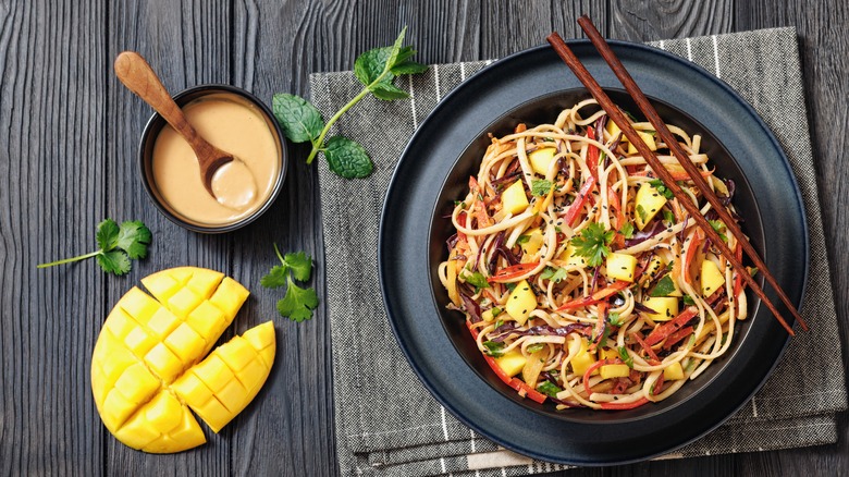 Thai mango noodle salad with peanut sauce in a bowl