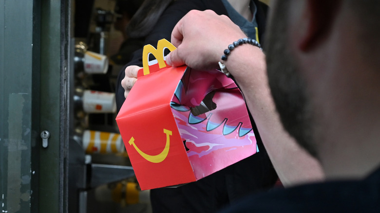 Person receiving a Happy Meal at a drive-thru