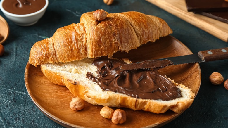 Croissant with chocolate spread and a knife