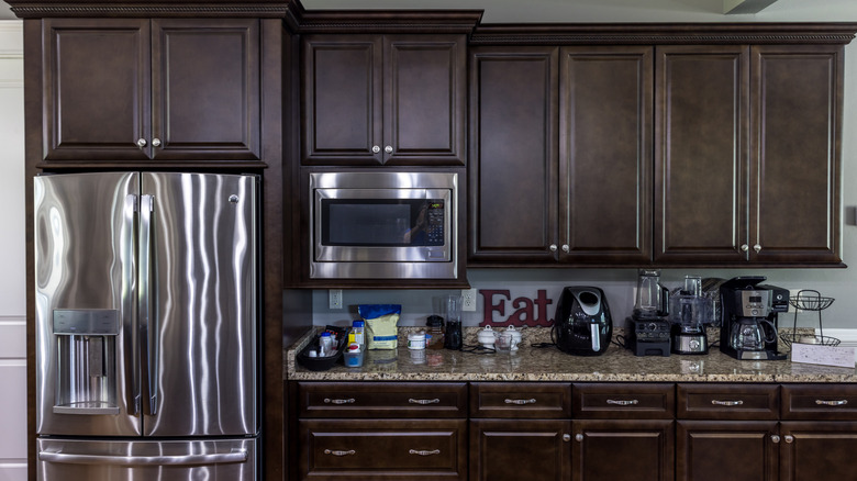 Several small appliances like a coffee maker are seen on a kitchen counter.