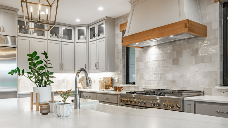 A bright, minimalist kitchen with a rustic, white full backsplash that adds texture and character.