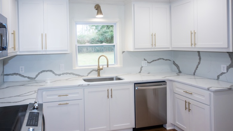 White shaker-style kitchen cabinets with gold hardware