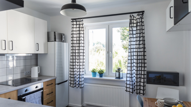 A simple, modest-sized kitchen with patterned curtains