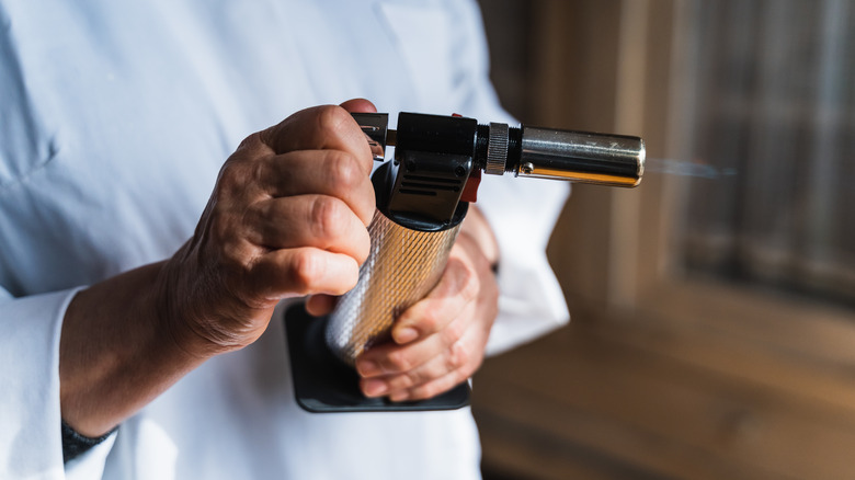 chef holding a lit kitchen torch
