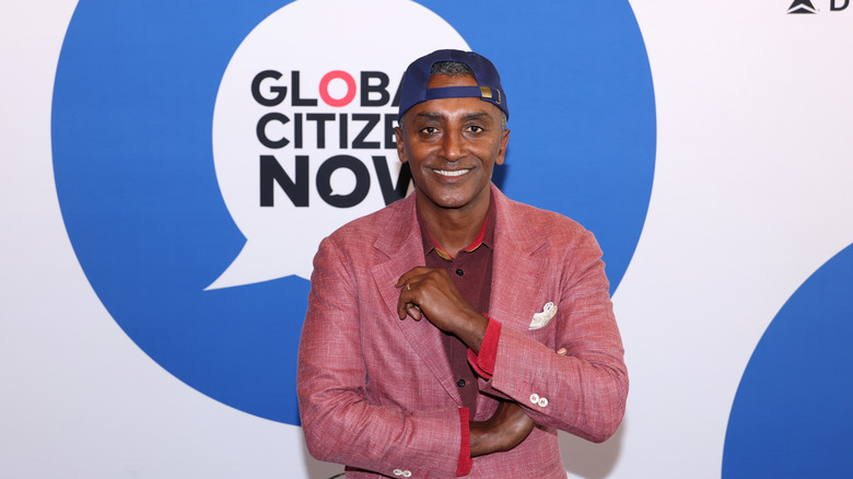 Chef Marcus Samuelsson wearing a pink sports jacket and blue cap