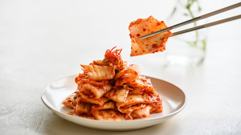 Heaping plate of kimchi with chopsticks
