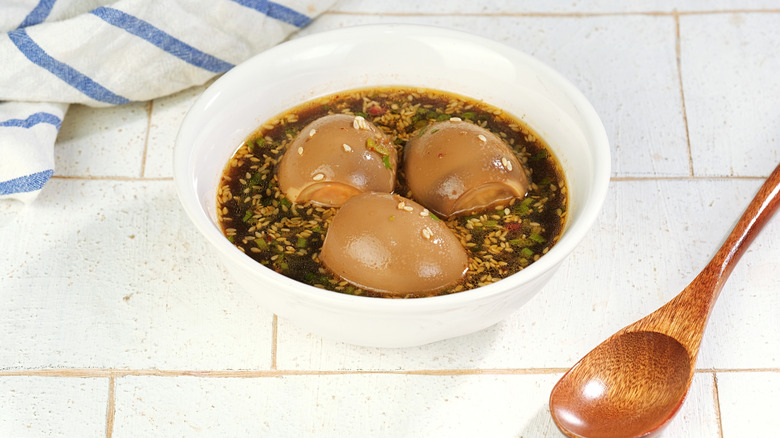 A bowl of mayak eggs with a wooden spoon placed beside it