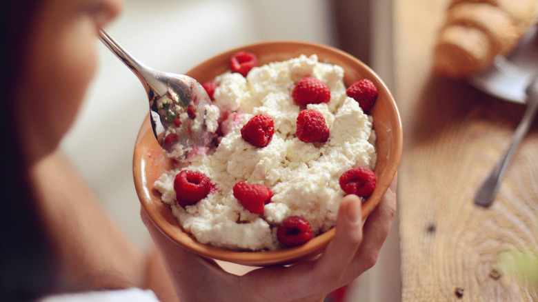 woman eating cottage cheese with raspberries