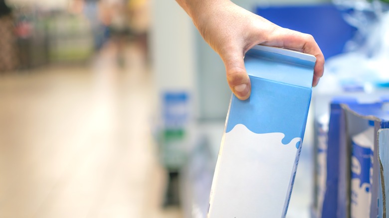 Hand reaching for carton of cream