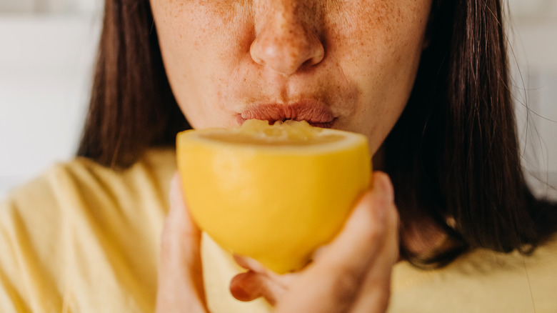 Person eating lemon half