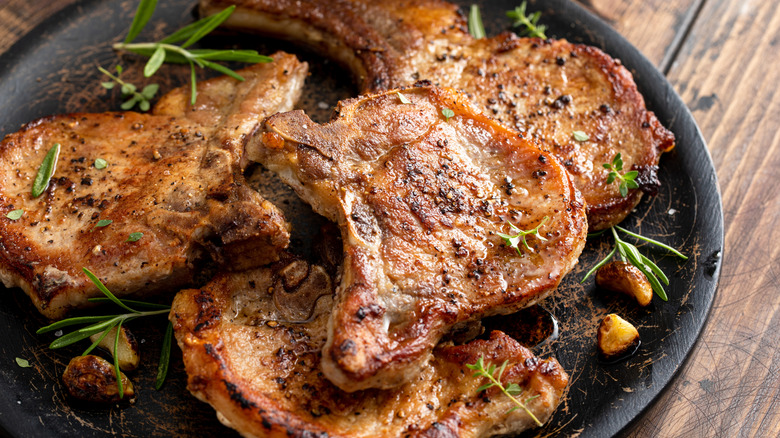Seasoned grilled pork chops on a plate.