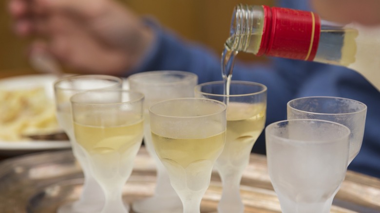 Pouring aquavit from a bottle