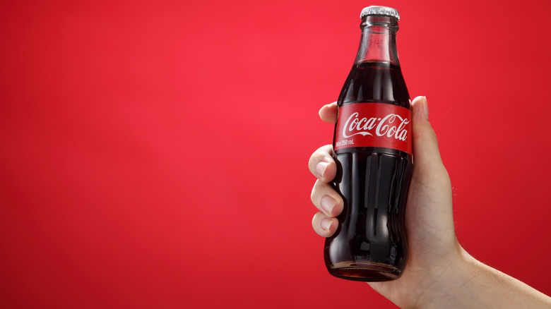 Hand holding Coca-Cola bottle