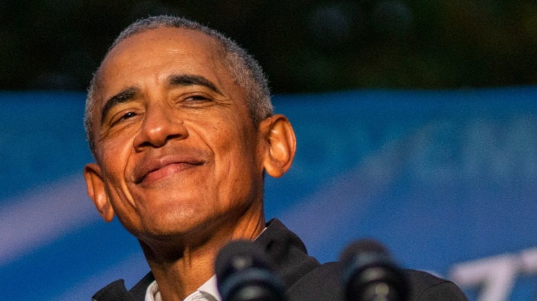Barack Obama smiles as he speaks onstage