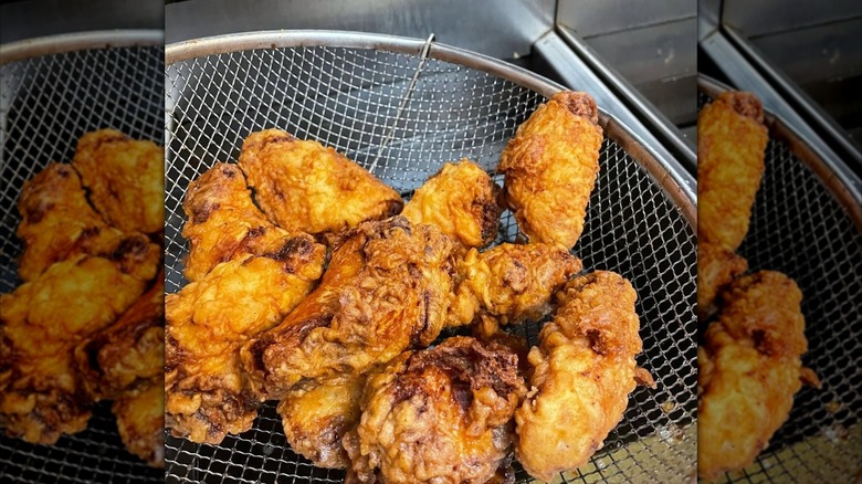 Fried chicken wings coming out of the fryer from 77 Kentucky
