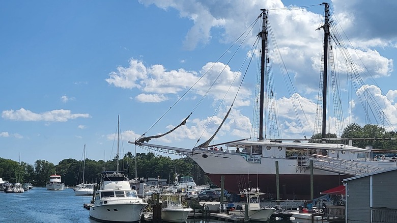Photo of The Spirit of Massachusetts sailboat on a dry dock in a harbor surrounded by other boats