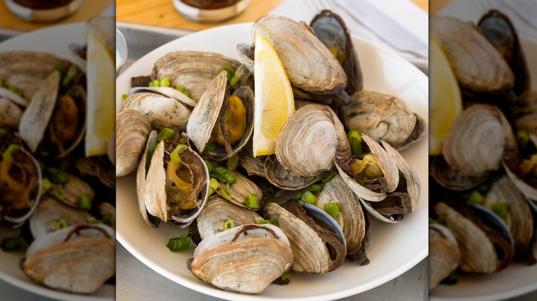 Steamed clams topped with green onions and lemon