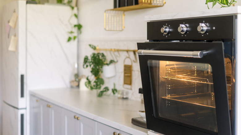 black oven mounted in the wall in a white kitchen