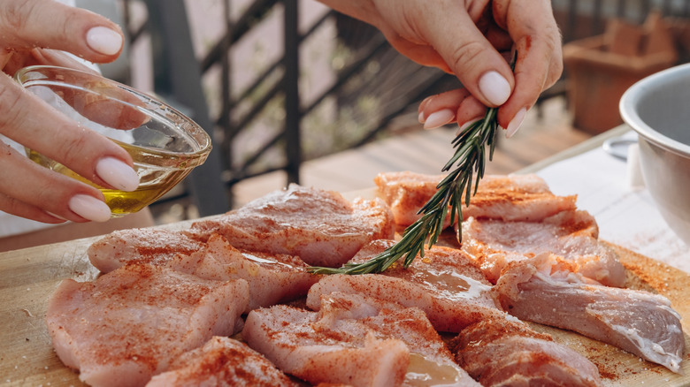 Adding oil and herb marinade to fresh meat