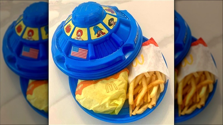 A blue Spaceship Happy Meal with stickers.
