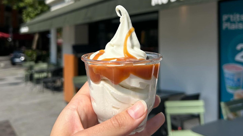 Close-up of a hand holding a McDonald's caramel sundae outside of a McDonald's in Paris, France