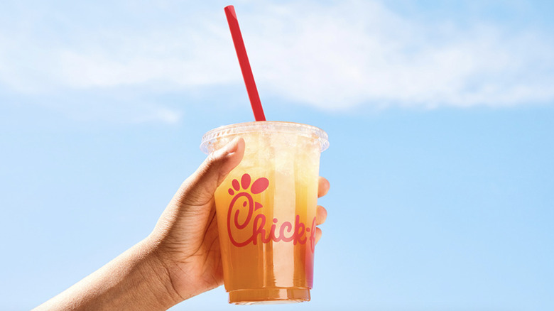 A hand holds a cup of Chick-fil-A iced tea.
