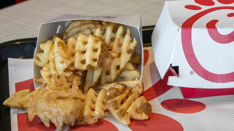 Chick-fil-A Waffle Potato Fries sit on a tray next to a Chick-fil-A box.
