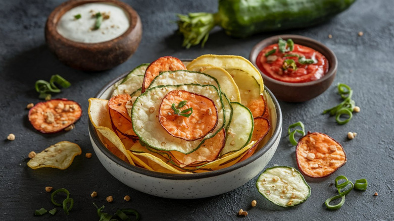 Veggie chips in a bowl with dips on the side