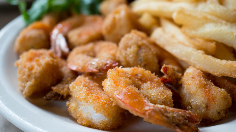 fried shrimp close up on a plate with french fries