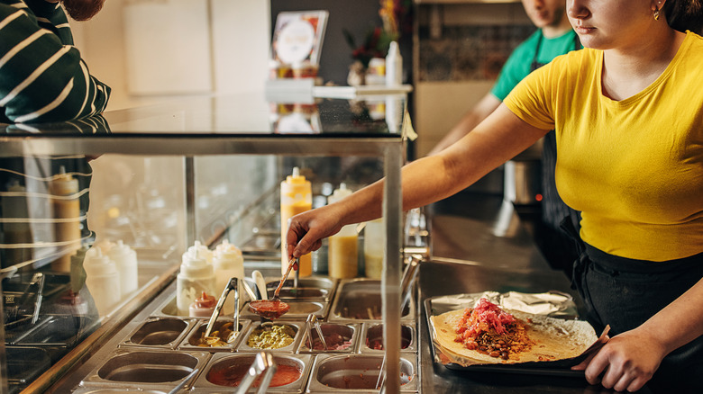 Person serving themselves salsa at a Mexican restaurant
