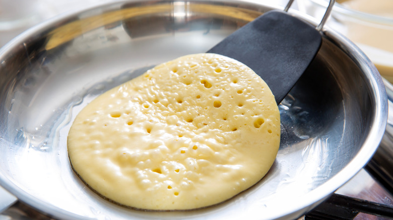 Person flipping pancake on a skillet