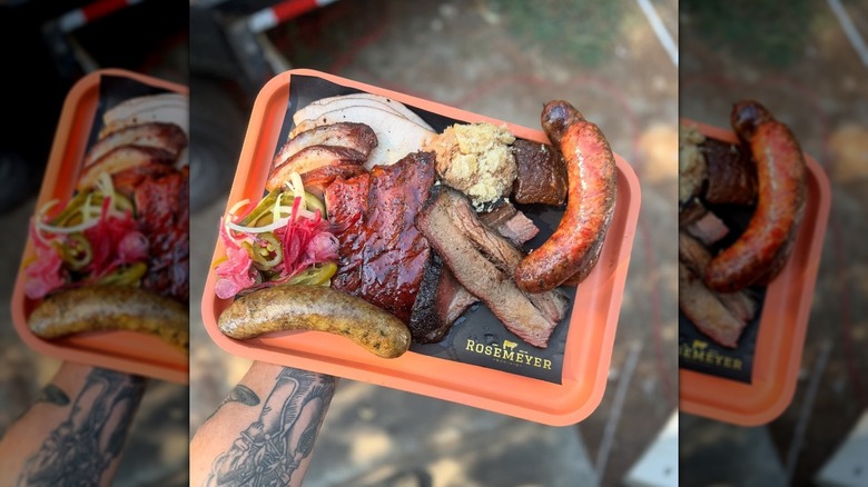 A tattooed arm holding a Rosemeyer Bar-B-Q plate