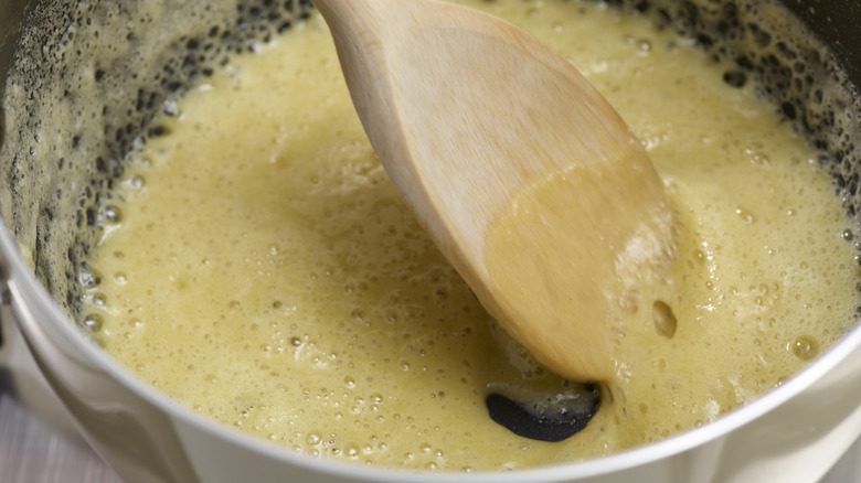 wooden spoon stirring blond roux