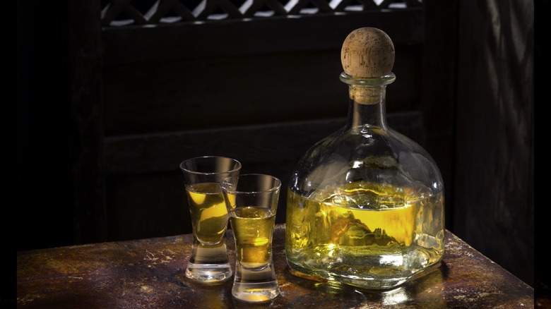 A bottle of añejo tequila with two shot glasses