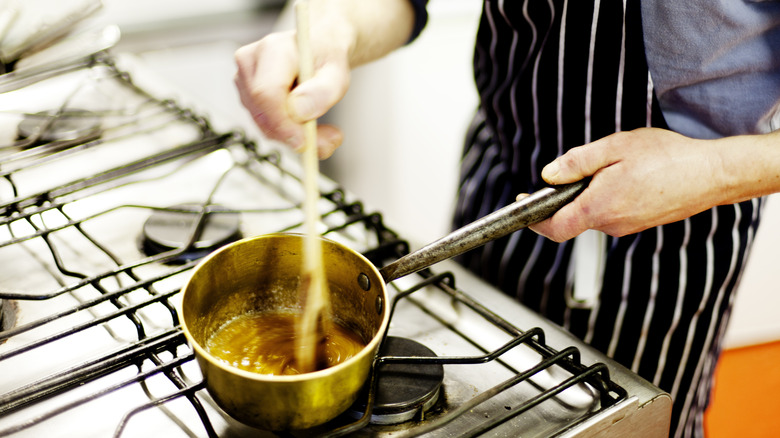 Person mixing caramel in pot