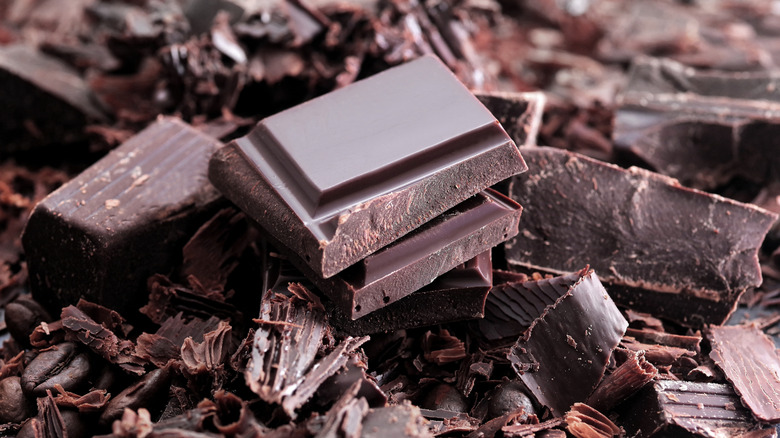 Close up of a bar of dark chocolate broken into pieces.