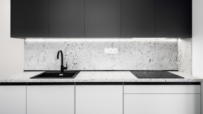 Kitchen cabinetry with a sink and range top