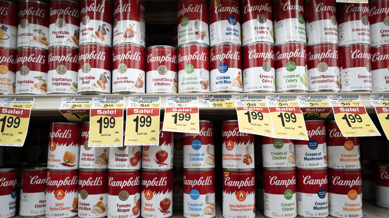A large amount of Campbell's Soup cans stacked together in a grocery store aisle