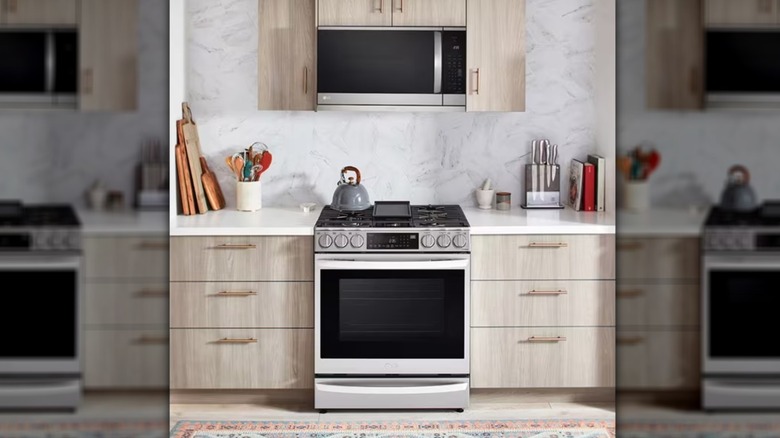 LG over-the-range microwave installed in a kitchen with light wood cabinets